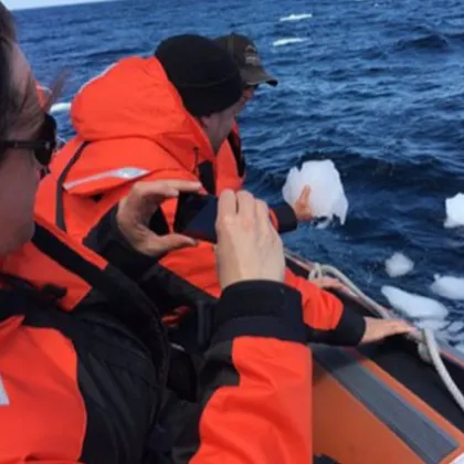 a group of people standing next to a body of water