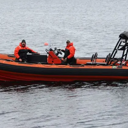 a group of people in a small boat in a body of water